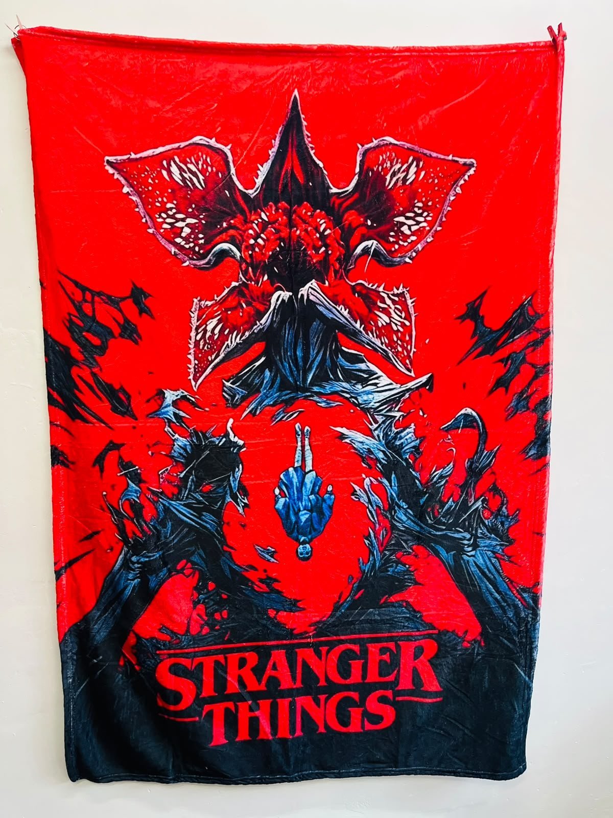 Frazada viajera de terror: el Demogorgon de Stranger Things sobre fondo rojo — foto de la frazada real