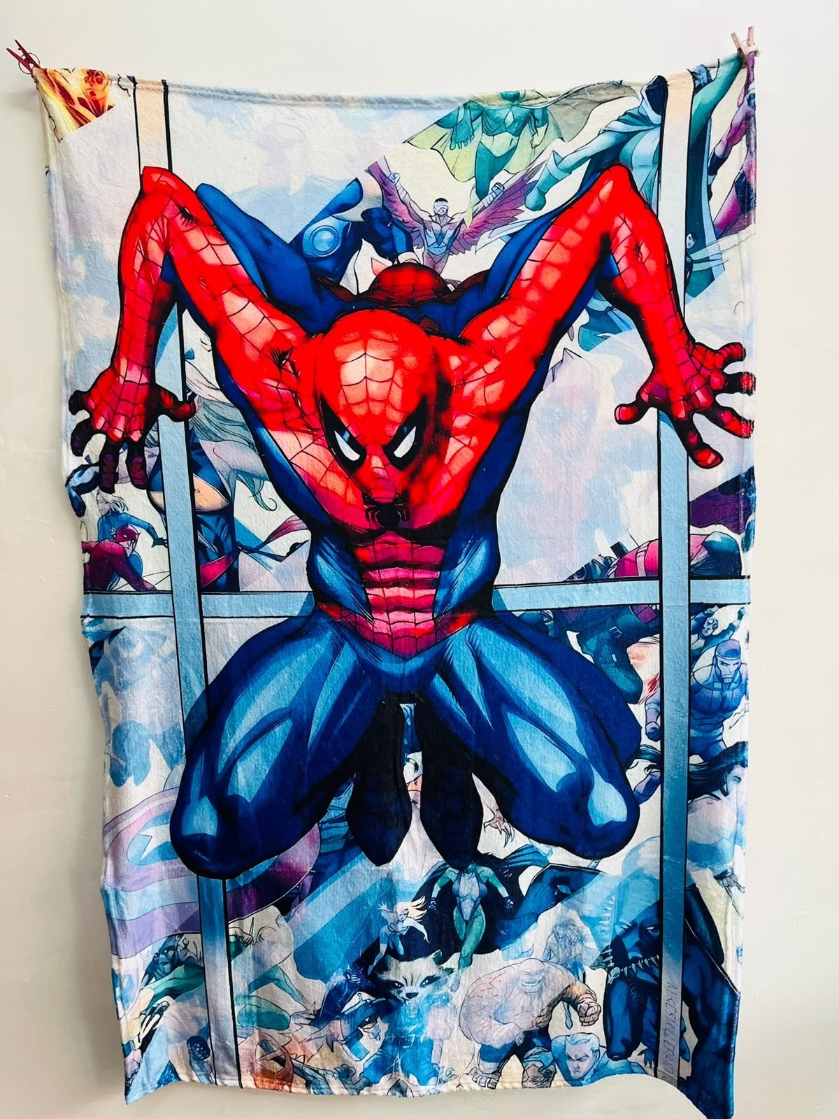 Frazada viajera Marvel: Spider-Man agachado entre edificios con colores de cómic — foto de la frazada real